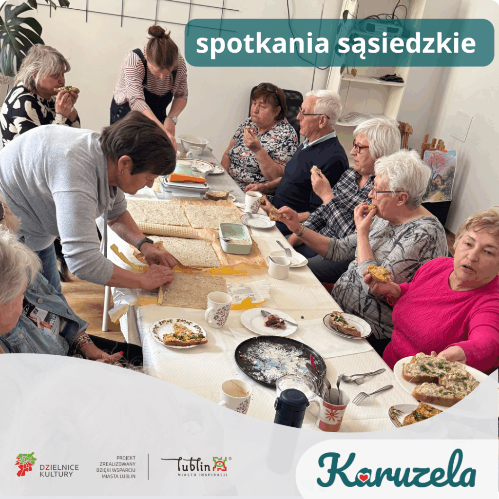 Żywiołowa grupa seniorów, zgromadzonych wokół stołu z jedzeniem. Niektórzy przygotowują jedzenie, inni jedzą lub rozmawiają. Grafika jest opatrzona napisem "spotkania sąsiedzkie". Na dole grafiki logotypy - Karuzela, Lublin Miasto Inspiracji, Dzielnice Kultury oraz tekst "Projekt zrealizowany dzięki wsparciu Miasta Lublin"
